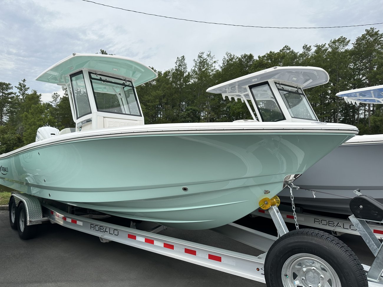 The definition of an outboard motor is a detachable engine mounted on outboard brackets on the stern of your boat.  This configuration will have only one single engine.